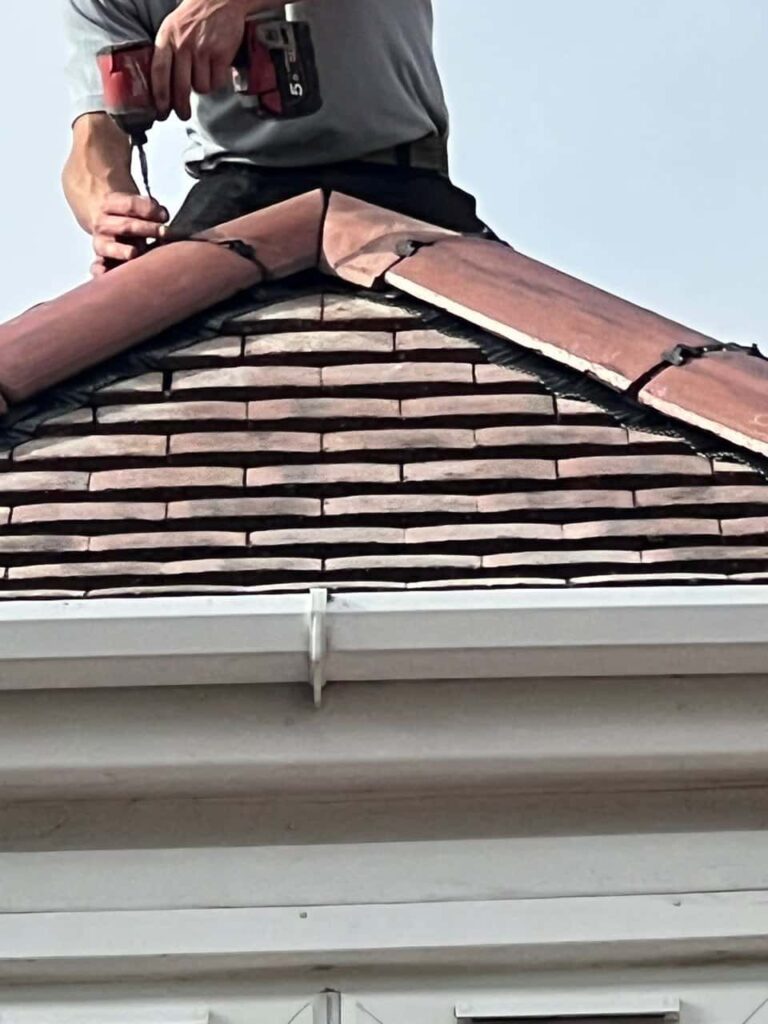 This is a photo of one of the operatives of LJ Roofing Melksham installing new ridge tiles